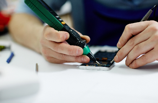 Technician testing a phone board with a multimeter